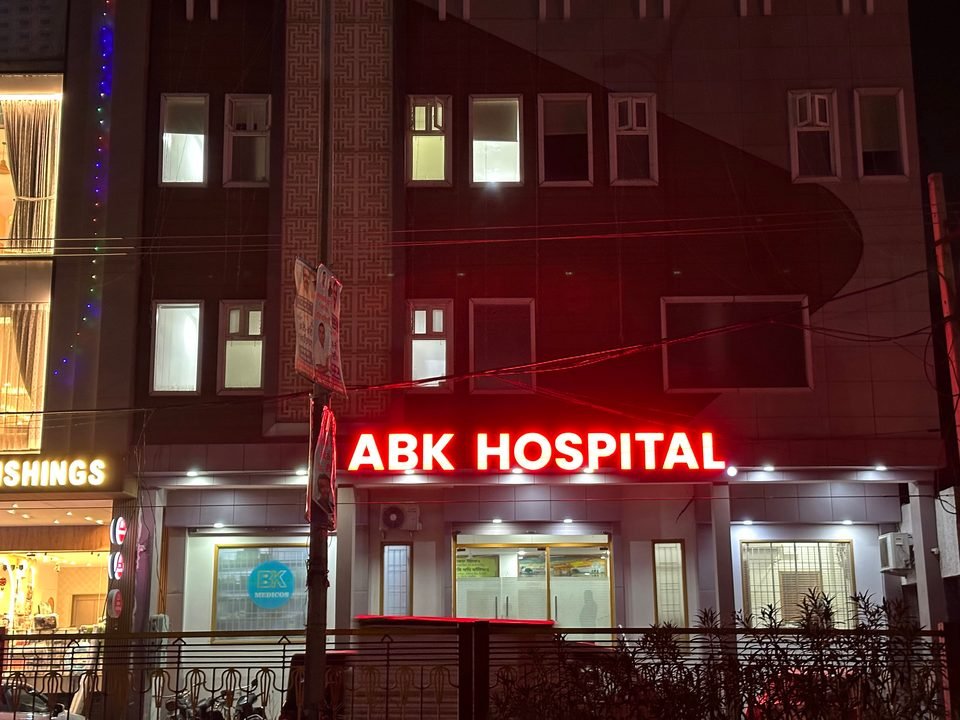 ABK Hospital at night, with its red sign lit above the entrance